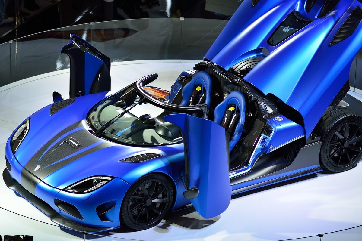 Hypercar with doors raised in a dark studio